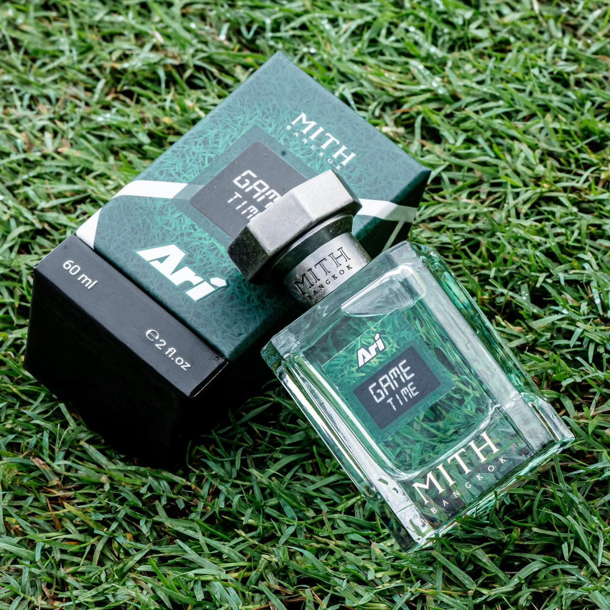 MITH × Ari Game Time bottle and 60 ml box lying on grass