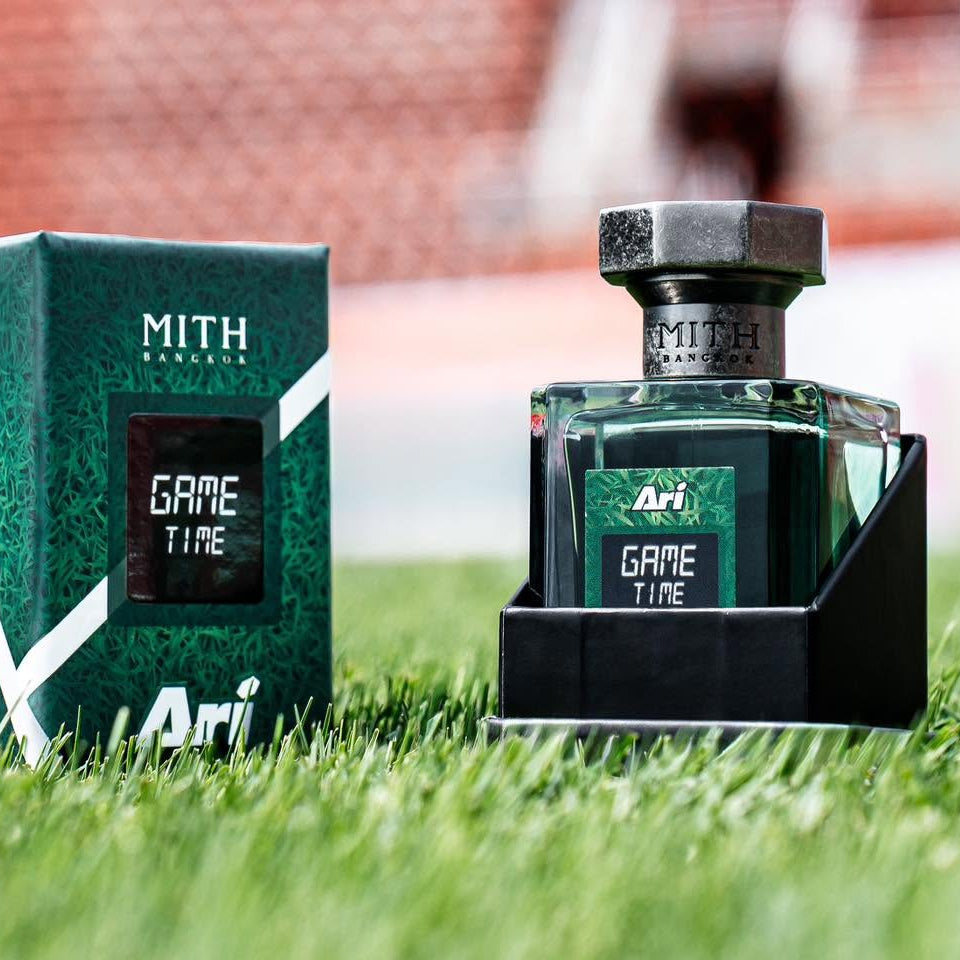 MITH × Ari Game Time perfume bottle and green presentation box on a football pitch